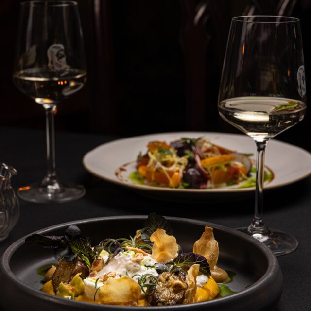 Assiettes raffinées et verres de vin au Bar George à Montréal.