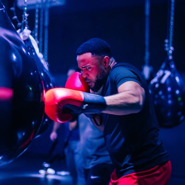 Participant frappant un sac de boxe pendant un entraînement de boxe fitness au Boxxing Studio à Montréal.