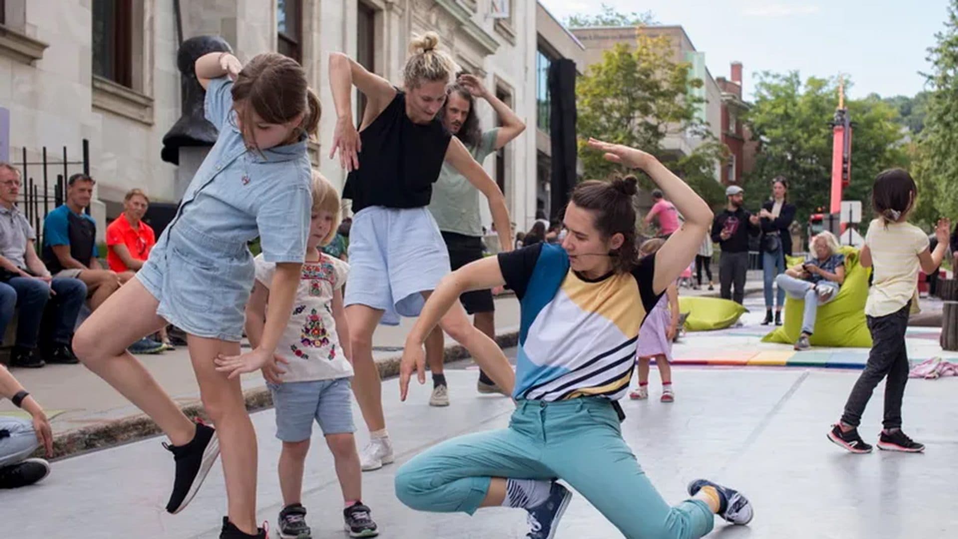 Enfants et adultes dansent lors d'un atelier-spectacle en plein air sur l'avenue du Musée.