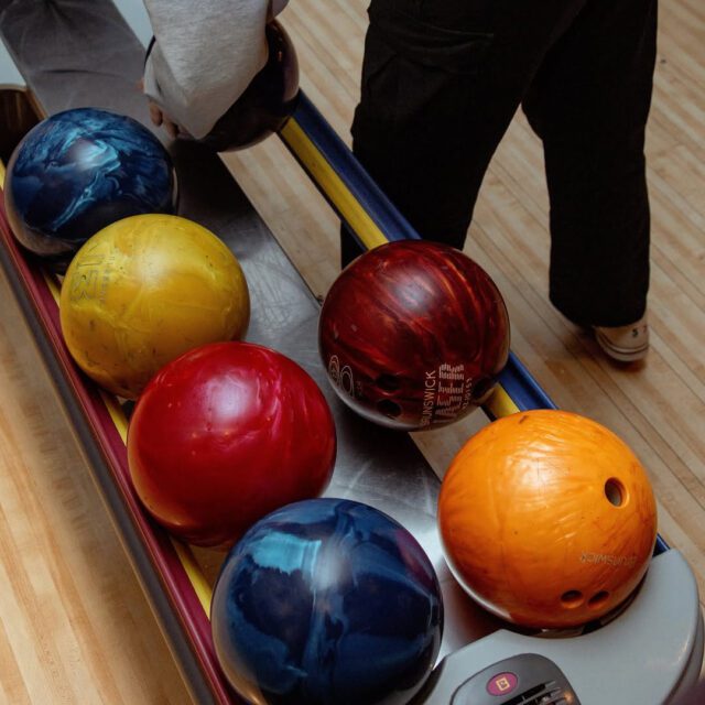 boules de bowling colorées alignées sur une piste au Montréal Bowling Fab.