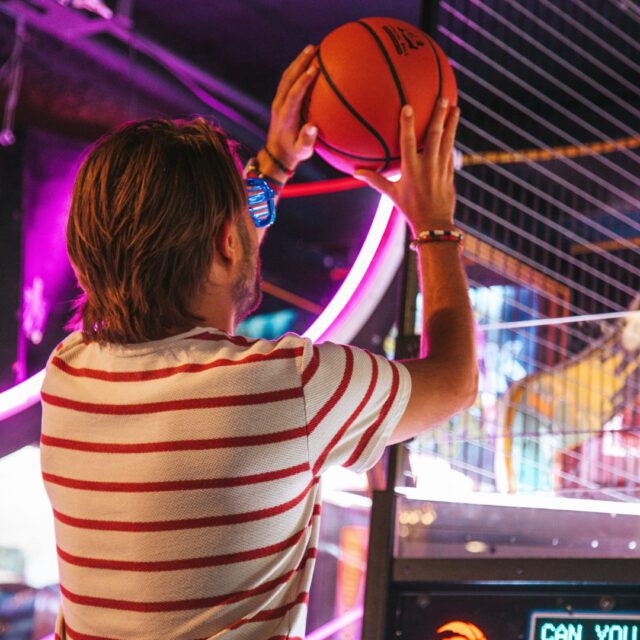 Famille s’amusant sur des jeux d’arcade et attractions interactives au centre de divertissement Les Trois Monkeys à Montreal.