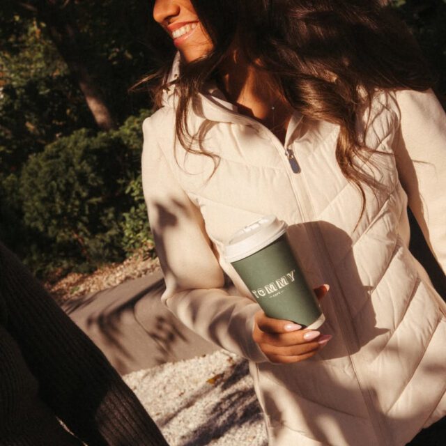 Femme tenant un café à emporter Tommy Café lors d’une promenade en ville à Montréal