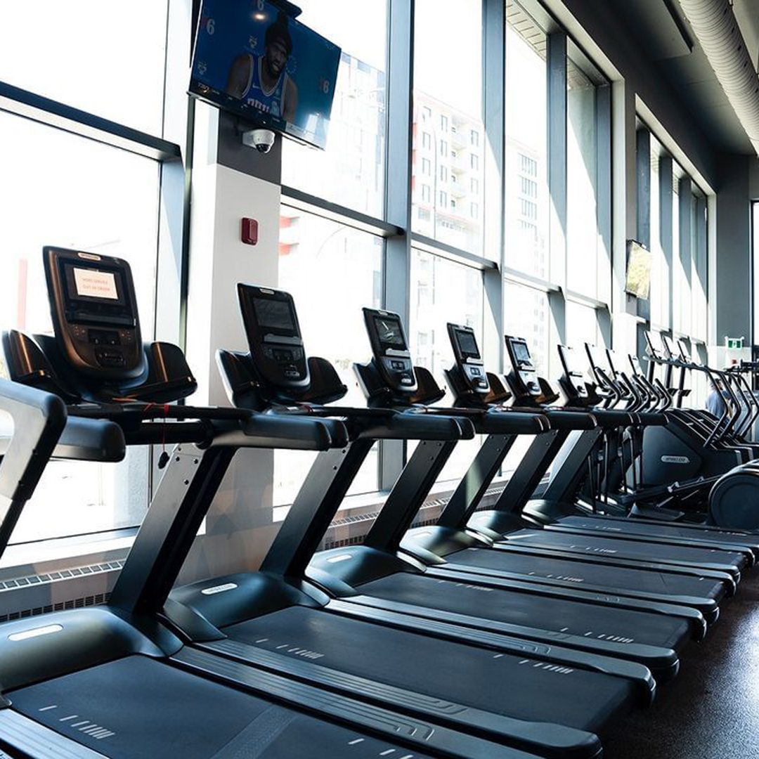 Anytime Fitness: Treadmills in a bright gym.