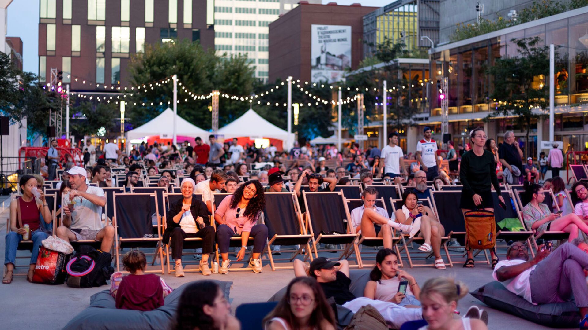 Spectateurs profitant d'une projection en plein air au Quartier des spectacles, Montréal