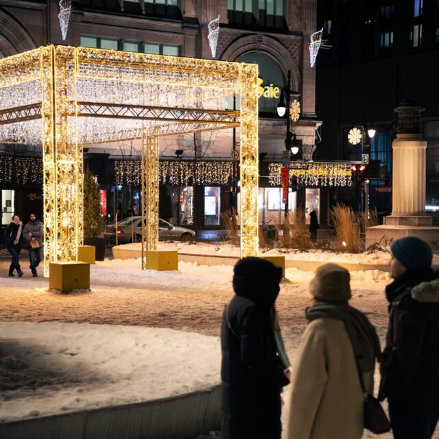 Un groupe d'amis devant les illuminations hivernales du square Phillips au centre-ville de Montréal