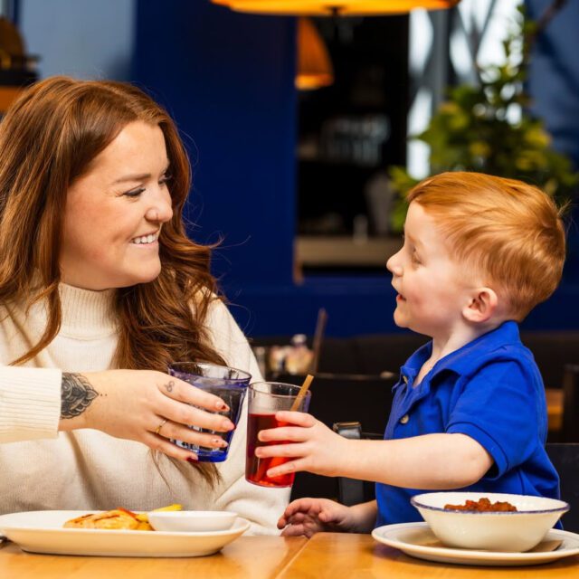 Mère et enfant qui font un cheers au Cochon Dingue  au centre-ville de Montréal