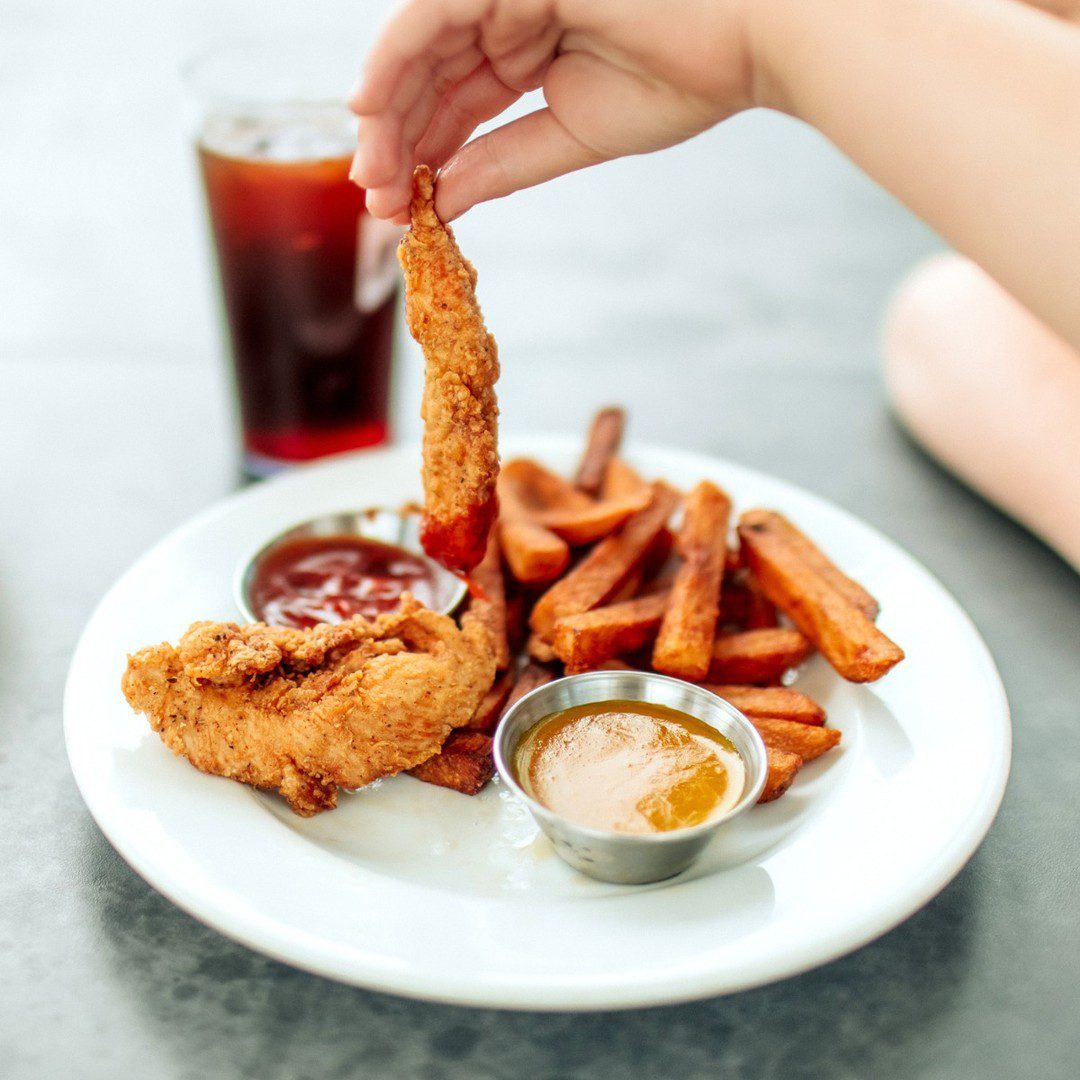 Tenders de poulet et frites pour enfants au restaurant La Cage à Montréal, idéal pour un repas en famille.