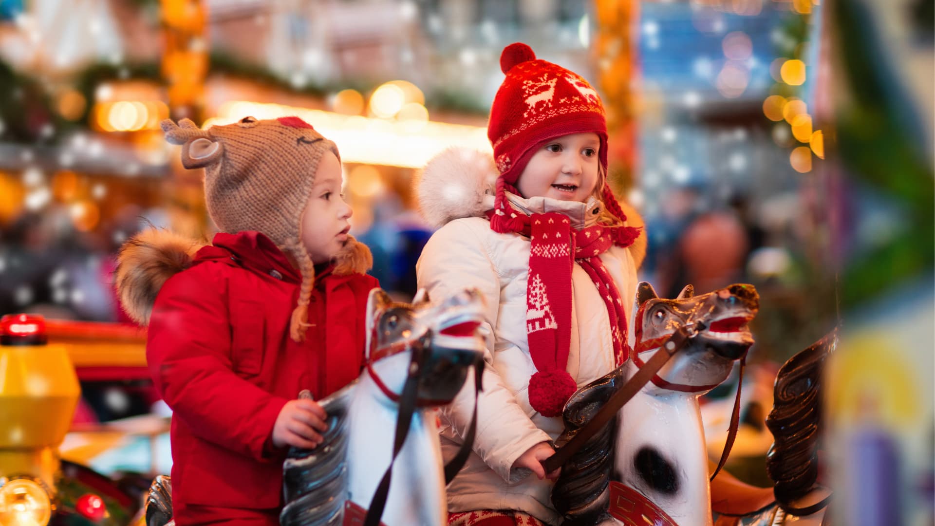 Enfants sur un manège avec des chevaux de bois en hiver à noël