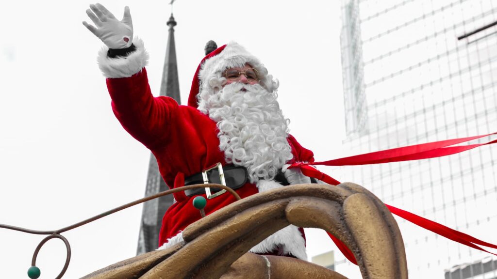 Père Noël défilant en traîneau avec ses rennes au centre-ville de Montréal.