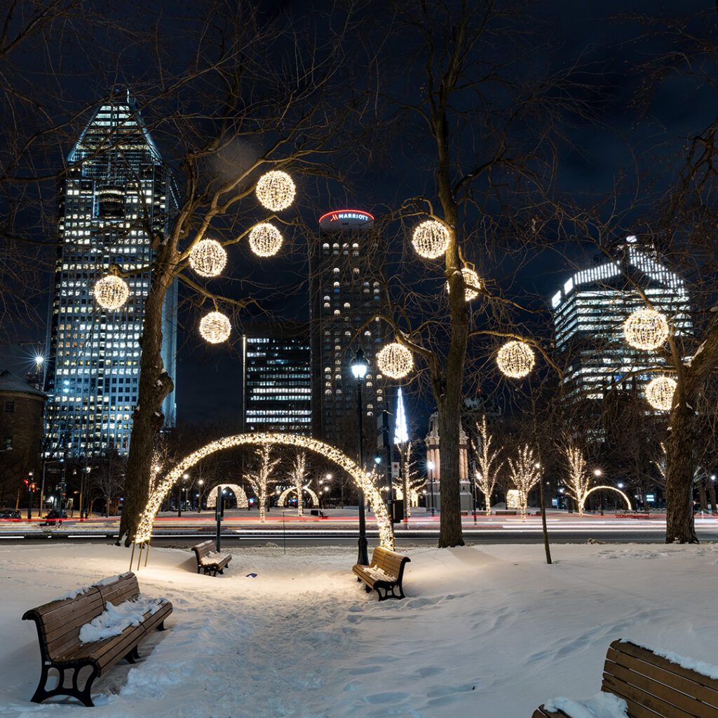 Installation lumineuse au Square Dorchester avec des arches scintillantes et des arbres décorés.