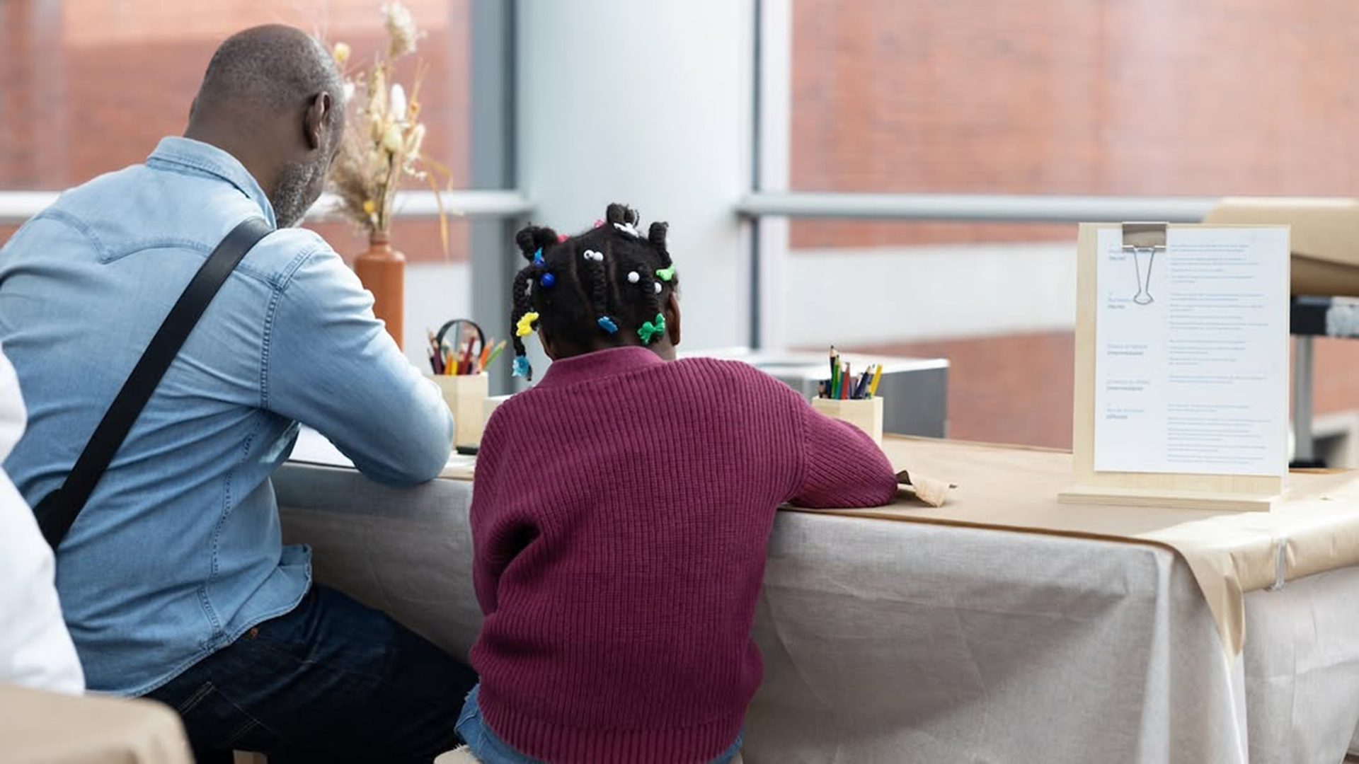 Un parent et un enfant participent à un atelier créatif au Musée des beaux-arts de Montréal.