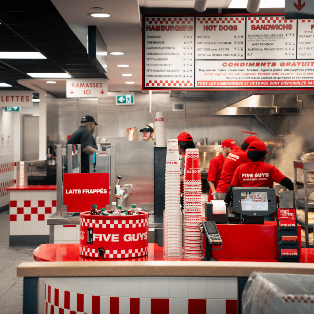 Les employés du FiveGuys qui travaillent pour préparer les hamburgers