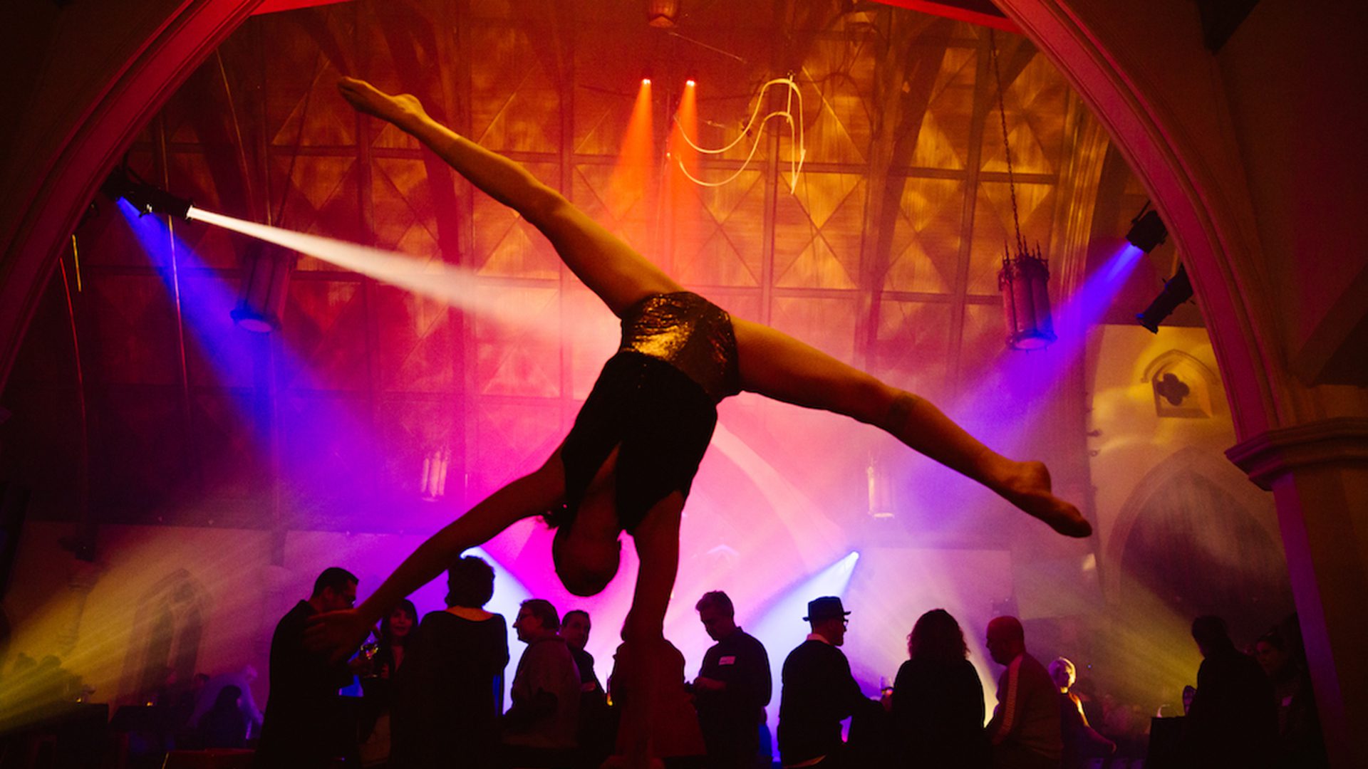 Circus artist balancing under the lights of the Cabaret de cirque at Le Monastère in Montreal.