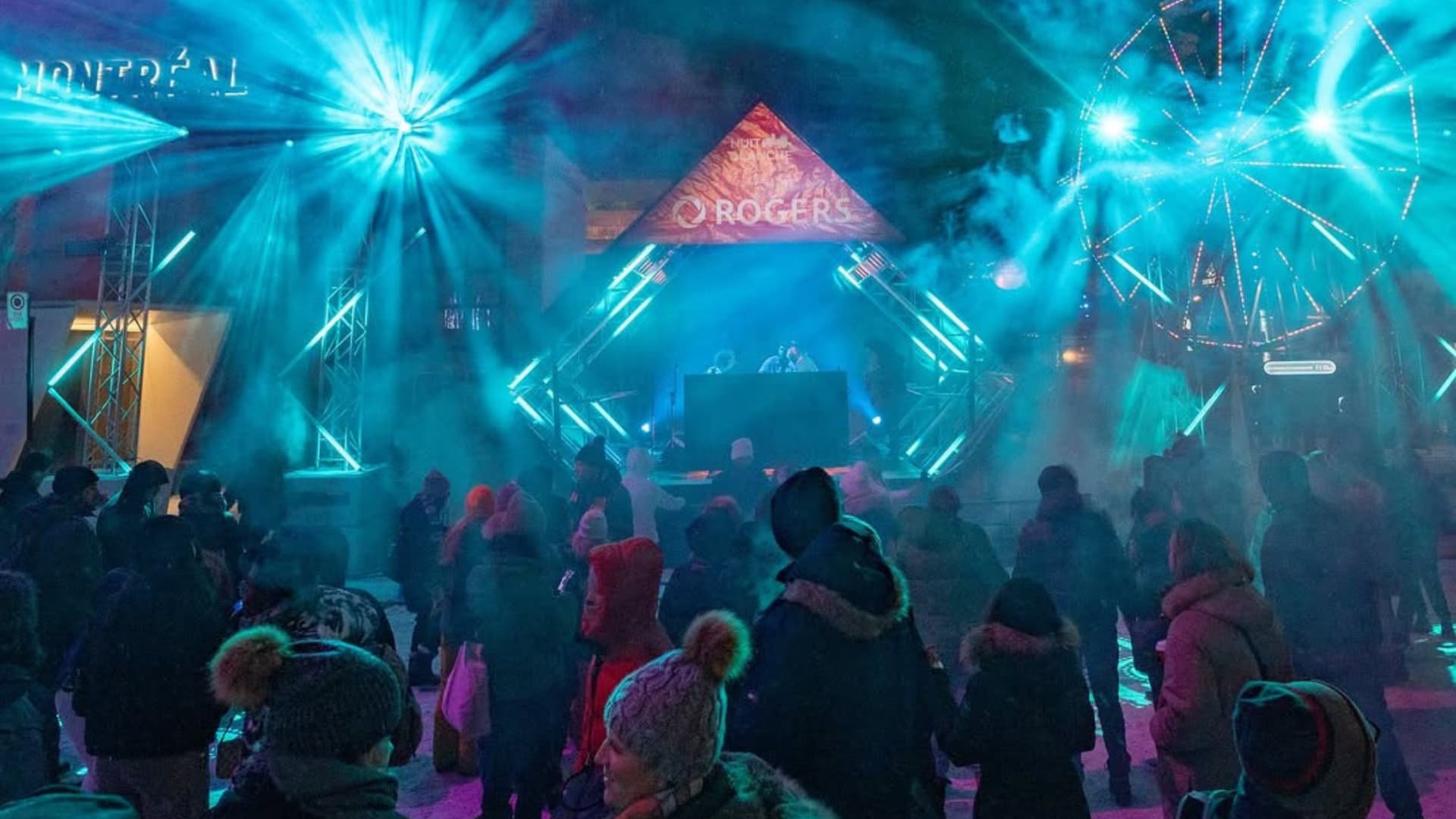 Foule animée lors de la Nuit blanche à Montréal au Quartier des spectacles, illuminée par des installations lumineuses et une ambiance festive.