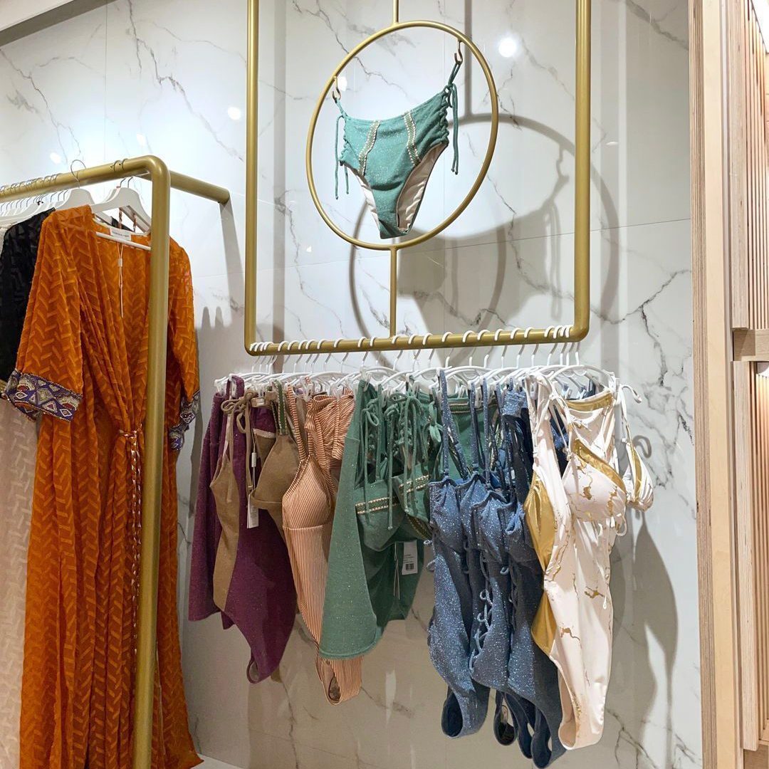 Elegant boutique showcasing refined swimwear displayed on a golden rack.