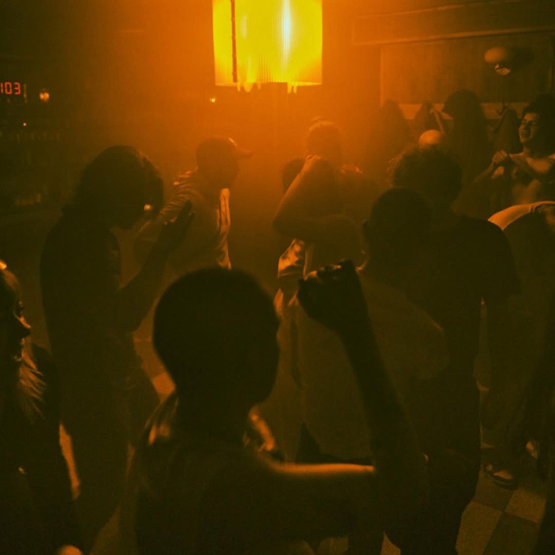 Danseurs sous une lumière tamisée au bar Sans Soleil.