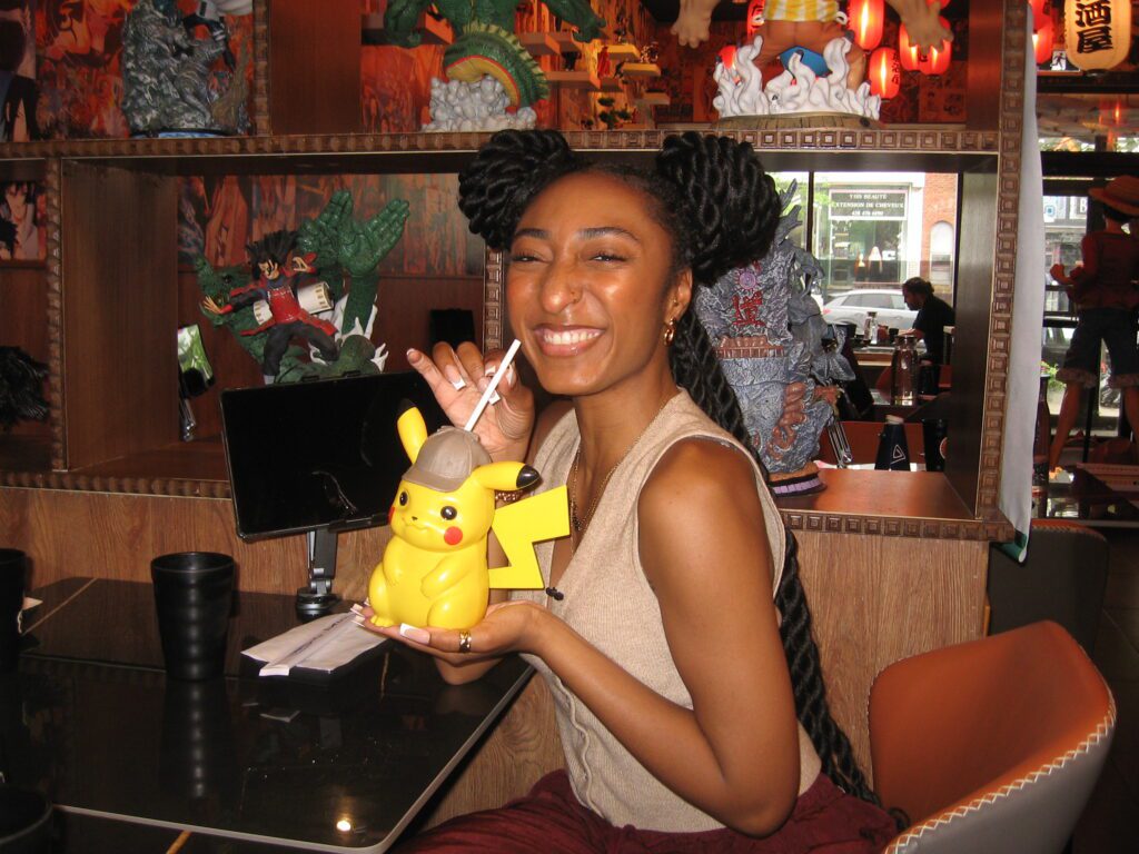 Angie Augustin qui boit dans une tasse en forme de Pikachu.