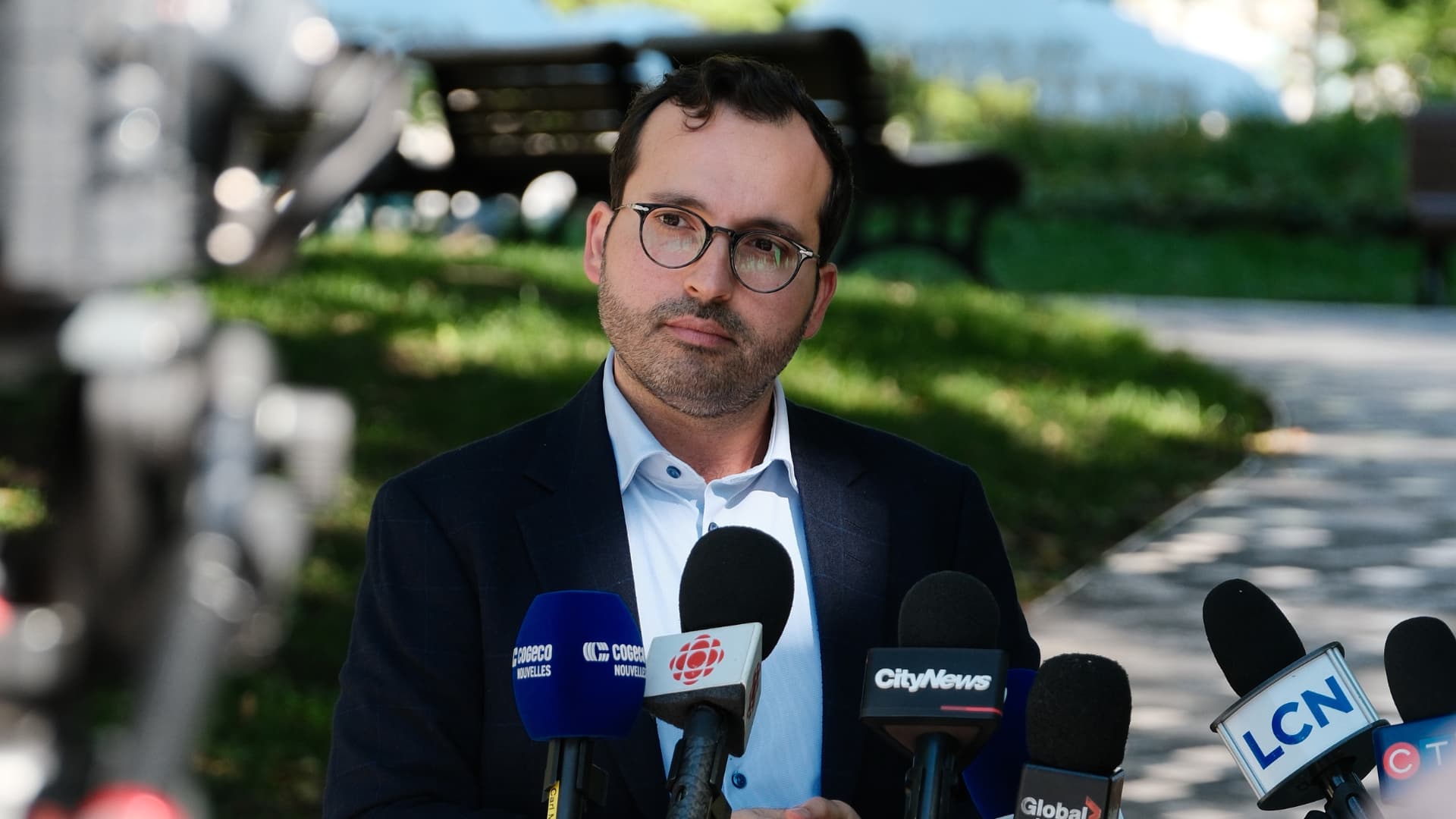 Glenn Castanheira se tient devant les micros des journalises présents lors de la conférence de presse