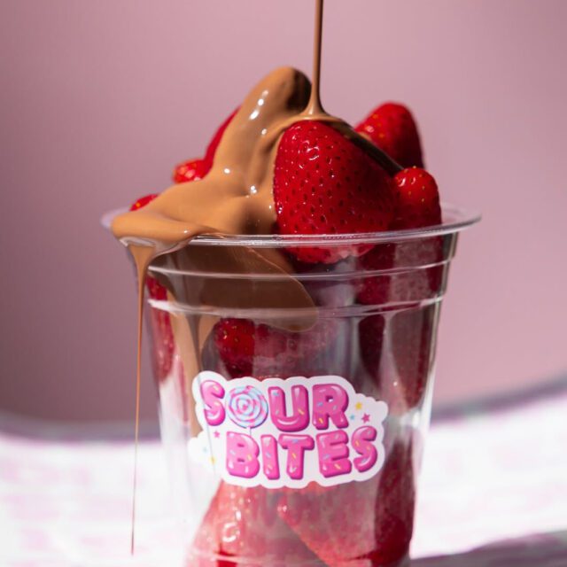 Fruits frais nappés de chocolat fondant et bonbons colorés chez Sour Bites à Montréal.