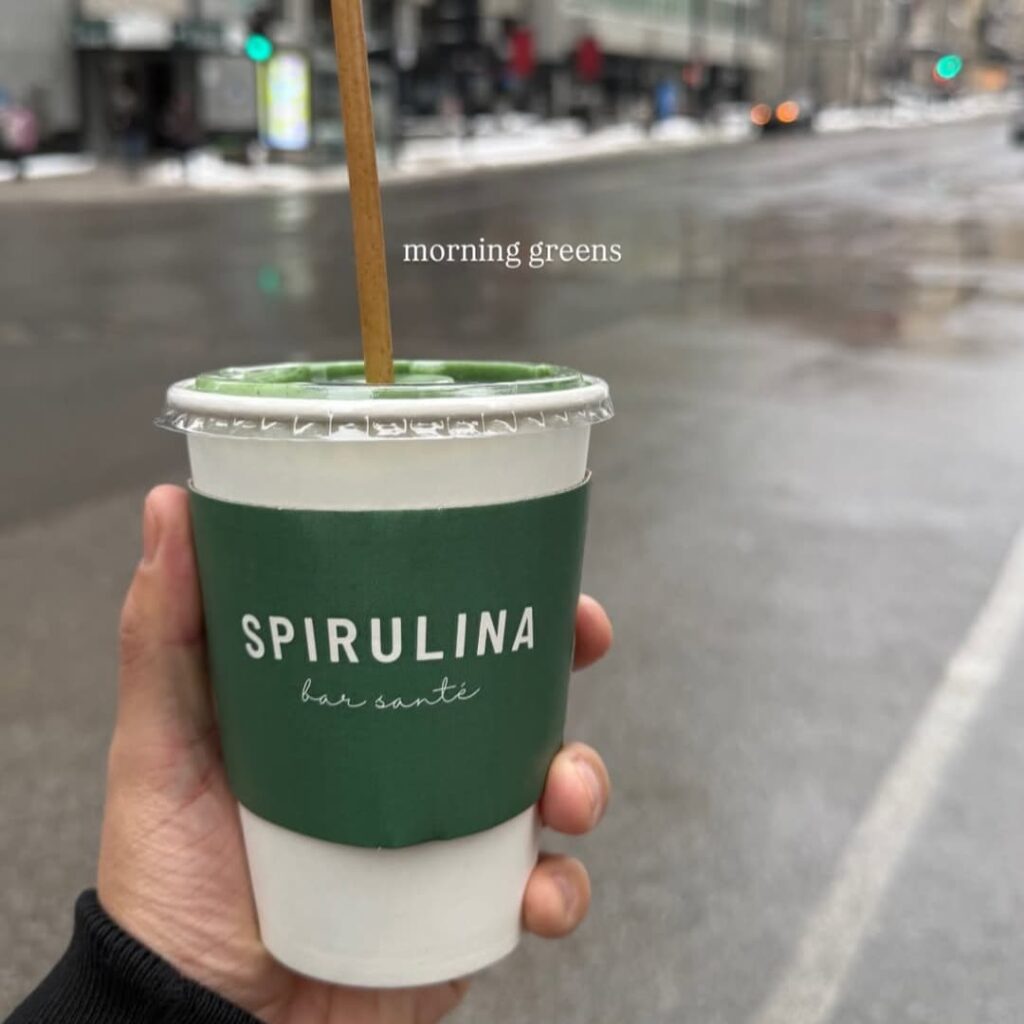Main tenant une boisson Spirulina